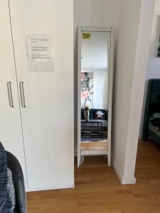 einen Flur mit einem Spiegel und einem Stuhl in einem Zimmer in der Unterkunft Kölner City Stillvolle Apartment in Köln
