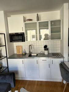 a kitchen with white cabinets and a sink at Kölner City Stillvolle Apartment in Cologne