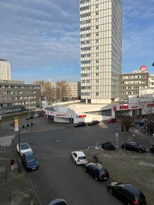 a parking lot with cars parked in front of a building at Kölner City Stillvolle Apartment in Cologne