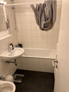 ein Badezimmer mit einem Waschbecken, einer Badewanne und einem WC in der Unterkunft Kölner City Stillvolle Apartment in Köln