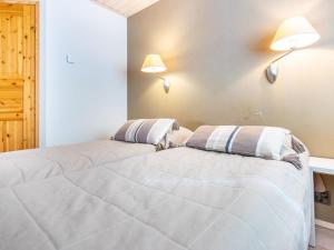 Dos camas en una habitación con dos lámparas en la pared. en Holiday Home Nilikuru e 12 by Interhome, en Saariselkä 10 fotos más