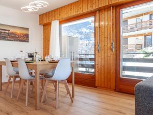 a dining room with a table and chairs and a window at Apartment Aiglon J2 by Interhome in Nendaz