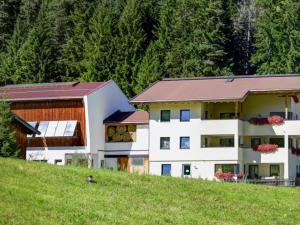 two buildings on a hill with trees in the background at Apartment Gampen by Interhome in Obergand