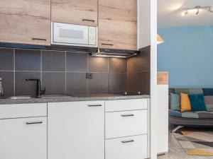 a kitchen with white cabinets and a microwave at Apartment Mont-Fort 26 by Interhome in Siviez