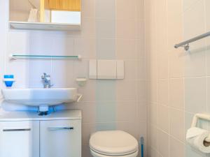 a bathroom with a toilet and a sink at Apartment Mont-Fort-29 by Interhome in Siviez