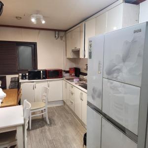 a kitchen with white cabinets and a refrigerator at Brown Hotel in Seoul