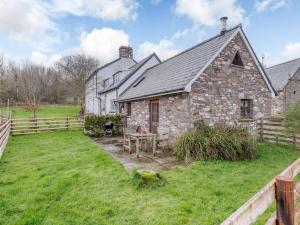 an old stone house with a picnic table in the yard at 1 bed in Cantref BN264 in Brecon