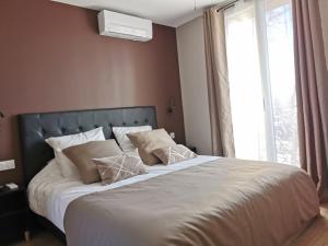 een slaapkamer met een groot bed met witte lakens en kussens bij Appart Hotel Cinéma Perpignan in Perpignan
