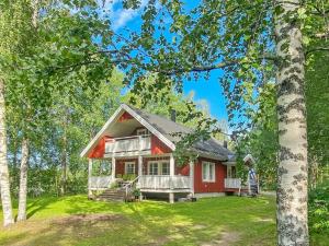 una casa roja con un porche en el bosque en Holiday Home Casa rantapirtti by Interhome en Jyväskylä
