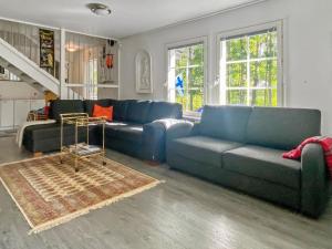 una sala de estar con sofás azules y una mesa. en Holiday Home Casa rantapirtti by Interhome, en Jyväskylä