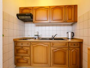 Una cocina con gabinetes de madera y un fregadero. en Holiday Home Bungalow 8 by Interhome, en Zinnowitz