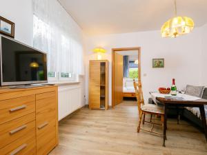 Un comedor con una mesa y un televisor. en Holiday Home Bungalow 8 by Interhome, en Zinnowitz