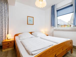 Un dormitorio con una cama con sábanas blancas y una ventana. en Holiday Home Bungalow 8 by Interhome, en Zinnowitz