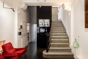 a hallway with a red chair and a staircase at Antiguo Brondo Selfcheck-in Smart Rooms in Palma de Mallorca