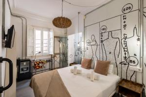 a bedroom with a white bed with a painting on the wall at Antiguo Brondo Selfcheck-in Smart Rooms in Palma de Mallorca