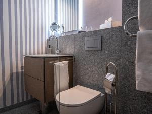 a small bathroom with a toilet and a sink at Apartment Chesa Sonnalpine B 55 by Interhome in St. Moritz