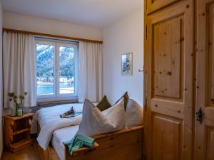 een slaapkamer met een bed en een raam bij Apartment Chesa Sonnalpine B 55 by Interhome in St. Moritz