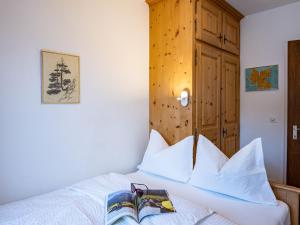 a bedroom with a bed with a book on it at Apartment Chesa Sonnalpine B 55 by Interhome in St. Moritz
