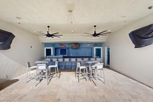 a room with tables and chairs and a kitchen at Sterling Breeze 1803 in Panama City Beach
