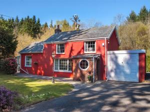 a red house with a garage in front of it at 2 Bed in Ystragynlais BN247 in Crynant