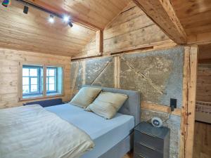 a bed in a room with a wooden wall at Holiday Home Im Rach by Interhome in Saas