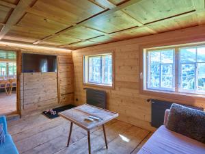 a living room with a table in a wooden cabin at Holiday Home Im Rach by Interhome in Saas