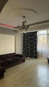 a living room with a couch and a window at Квартира посуточно in Almaty