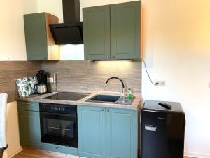 eine Küche mit blauen Schränken, einer Spüle und einem Herd in der Unterkunft Apartment Krabat by Interhome in Butterberg