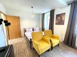 ein Zimmer mit einem Bett und zwei gelben Stühlen in der Unterkunft Apartment Krabat by Interhome in Butterberg + 3 Fotos