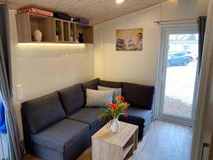 a living room with a couch and a table with flowers at Holiday Home Seeblick by Interhome in Wemding