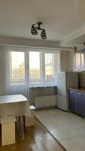 an empty kitchen with a table and a refrigerator at Квартира посуточно in Almaty
