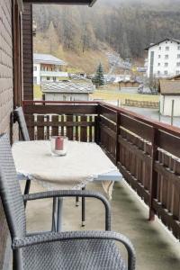 een tafel en stoelen op een balkon met een kopje erop bij Apartment Bergfreude by Interhome in Saas-Grund
