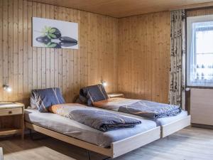 een slaapkamer met 2 bedden in een kamer met houten wanden bij Apartment Bergfreude by Interhome in Saas-Grund