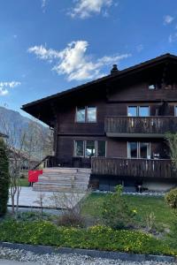 a large wooden house with a porch and a deck at Apartment Chalet Ilge by Interhome in Lenk