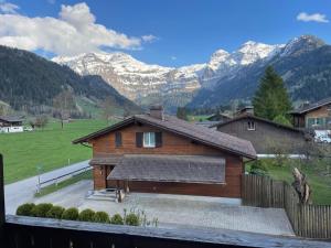 a wooden house with mountains in the background at Apartment Chalet Ilge by Interhome in Lenk
