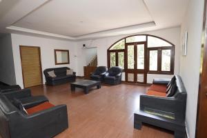 a living room with black leather furniture and an archway at Zeenath Taj Gardens in Yelagiri