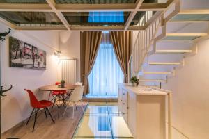 eine Treppe in einem Zimmer mit einem Tisch und Stühlen in der Unterkunft [Moscova - Garibaldi] Lusso, Sauna e Idromassaggio in Mailand