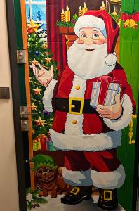 eine Weihnachtstür-Dekoration von Santa Claus mit Geschenken in der Unterkunft Apartament Primavera z sauną in Kielce