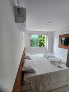 - une petite chambre avec un lit et une fenêtre dans l'établissement Porto Blue Makaranduba, à Porto de Galinhas