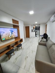 Il comprend un salon doté d'un canapé et d'une télévision à écran plat. dans l'établissement Porto Blue Makaranduba, à Porto de Galinhas