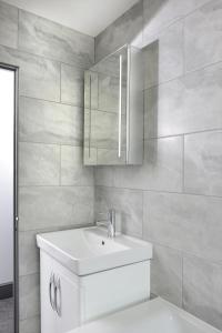 Baño blanco con lavabo y espejo en Refurbished House Long Stay Welcome Free Parking en Southampton