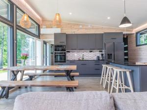 an open kitchen with a wooden table and chairs at Holiday Home Villa aura by Interhome in Pälkäne
