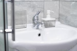 a bathroom sink with a faucet and a soap dispenser at Sky Rooms One Bedroom Modern Studio Apartment 8 in Birmingham