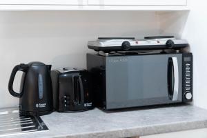 a kitchen counter with a microwave and a toaster oven at Sky Rooms One Bedroom Modern Studio Apartment 8 in Birmingham