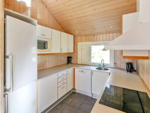 uma cozinha com electrodomésticos brancos e um tecto de madeira em Holiday Home Fredrike - all inclusive - 500m from the sea by Interhome em Vester Sømarken