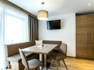 a dining room with a table and chairs and a tv at Apartment Top 6 - Panorama by Interhome in Ischgl