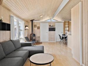 een woonkamer met een bank en een tafel bij Holiday Home Månviva - 500m from the sea in NW Jutland by Interhome in Løkken