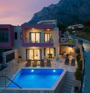 a house with a swimming pool in front of it at Villa Harmony in Makarska