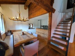 un comedor con una mesa de madera y una escalera en Apartment Ferienwohnung Selina by Interhome en Lenzerheide