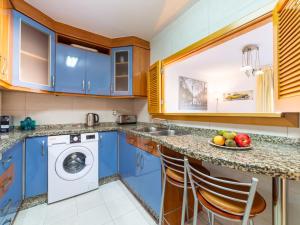a blue kitchen with a sink and a dishwasher at Apartment Dioniso - Playa Romanilla by Interhome in Roquetas de Mar